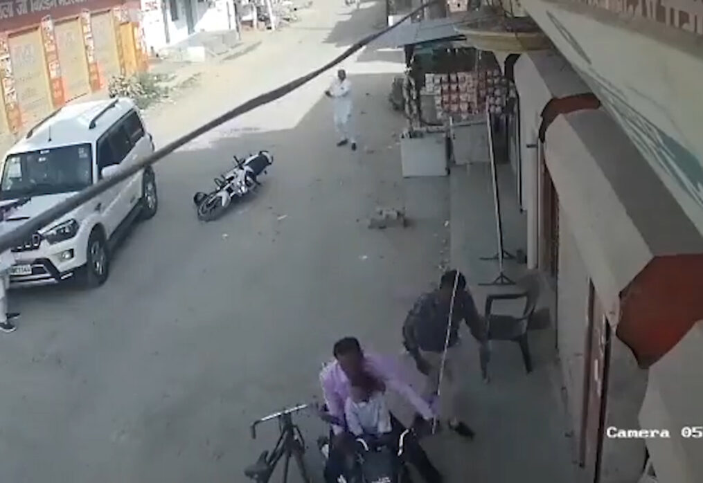 Two men threaten each other with weapons in middle of road in northern India