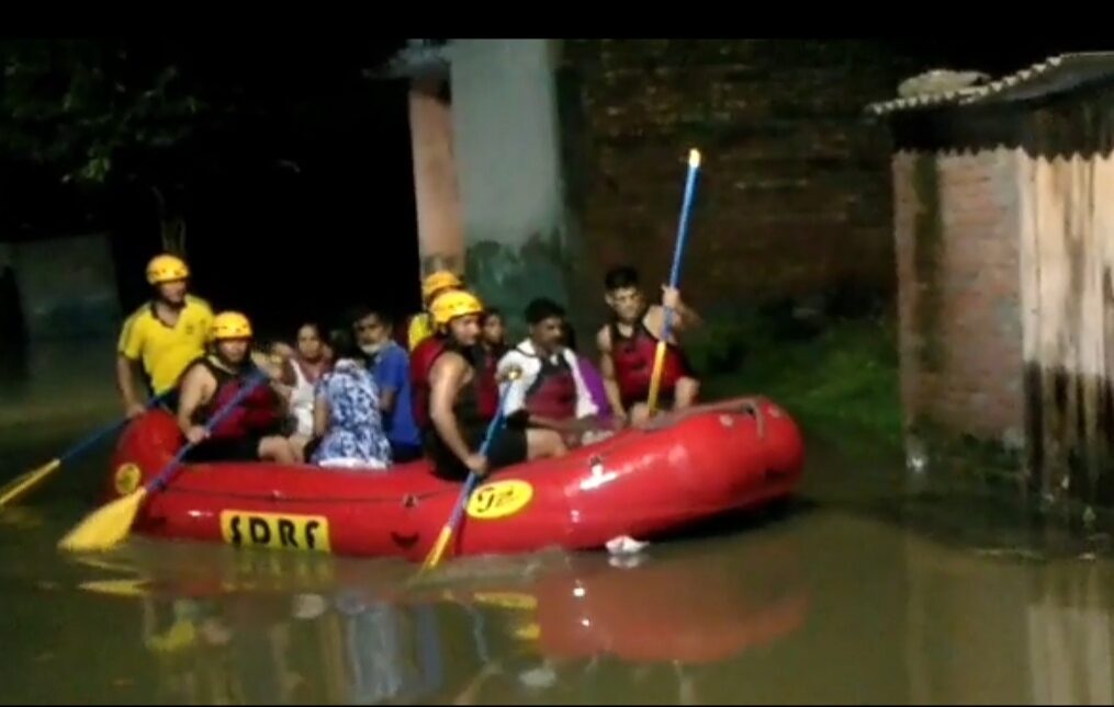 Rescue officials come to the aid of people stranded in submerged houses in northern India
