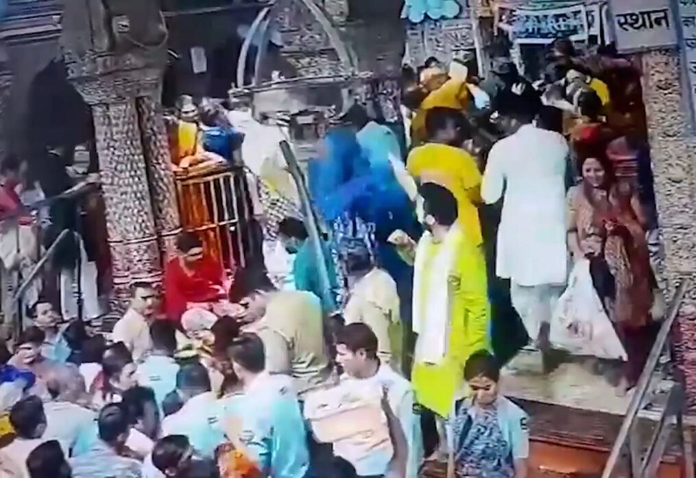 Devotee falls into crowd after climbing precariously on temple railing in northern India